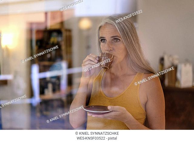 Portrait of businesswoman drinking cup of coffee in her shop