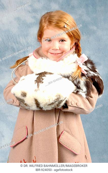 Little girl wearing a winter coat and a muff