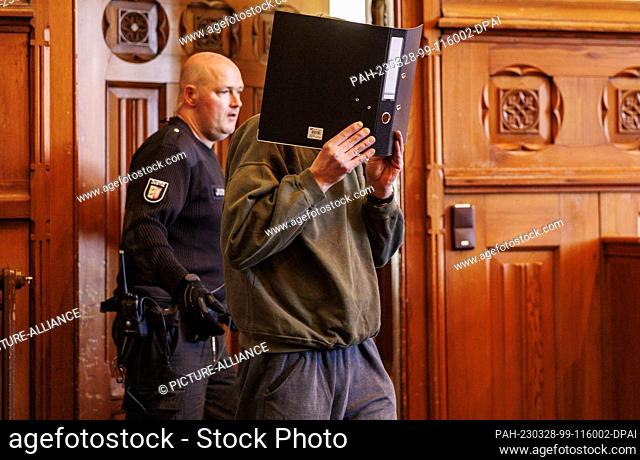 28 March 2023, Schleswig-Holstein, Flensburg: The 54-year-old accused alleged alternative practitioner is led into the courtroom at the beginning of the trial