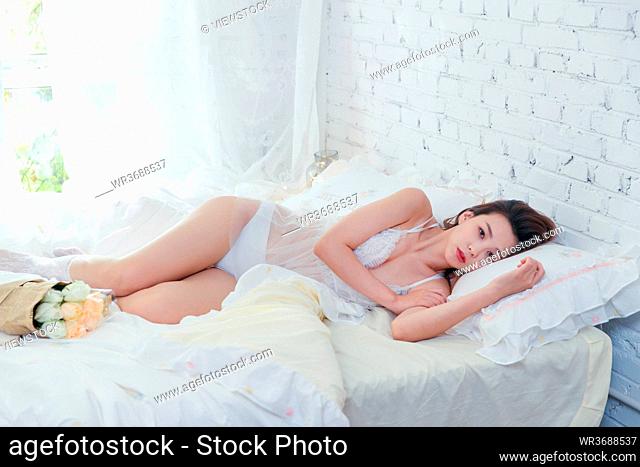 Beautiful young woman lying in bed