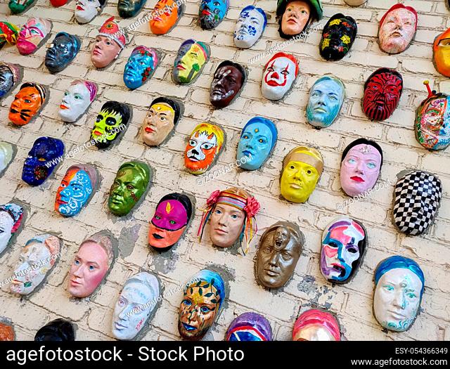 Moscow, Russia, 21 October 2019: Colorful painted ceramic faces sculpture on the bricks wall as an the object of modern art