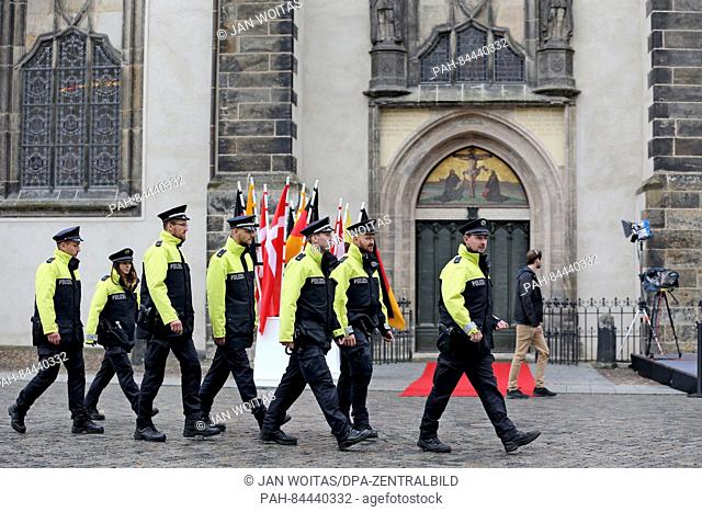 Police officers walk in front the All Saints' Church during the service in Wittenberg, Germany, 02 October 2016. Queen Margrethe II of Denmark is bringing an...