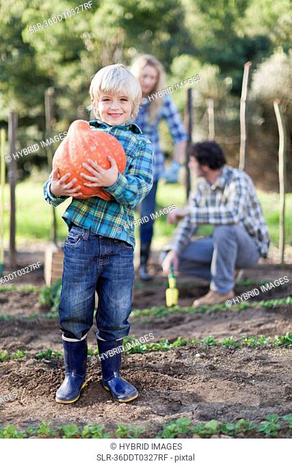 Boy carrying gourd in garden