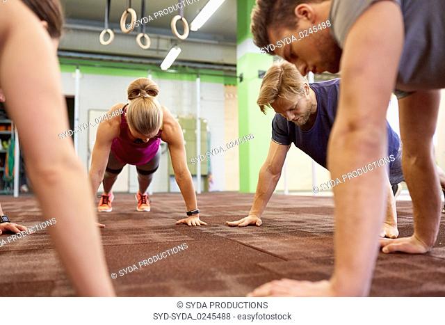 group of people doing straight arm plank in gym