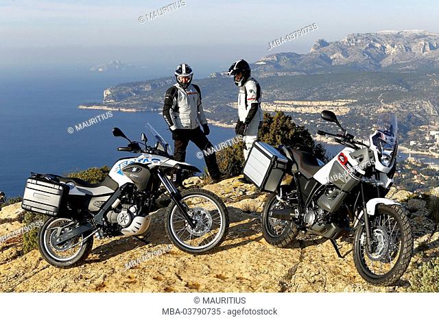 2 motorcycles, single cylinder Enduros, Yamaha Tenere and BMW G 650 GS, standing, drivers beside, coast, Southern France, Mediterranean Sea