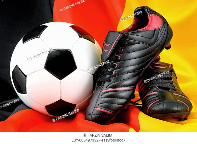 Fußball und Schuhe auf deutscher Flagge