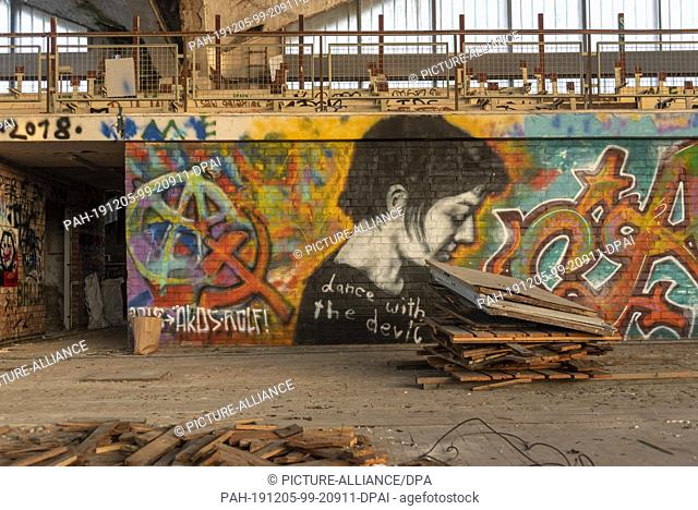 05 December 2019, Saxony-Anhalt, Magdeburg: In the interior of the hyparschale numerous graffitis are to be seen. In front of it lie the remains of a parquet...
