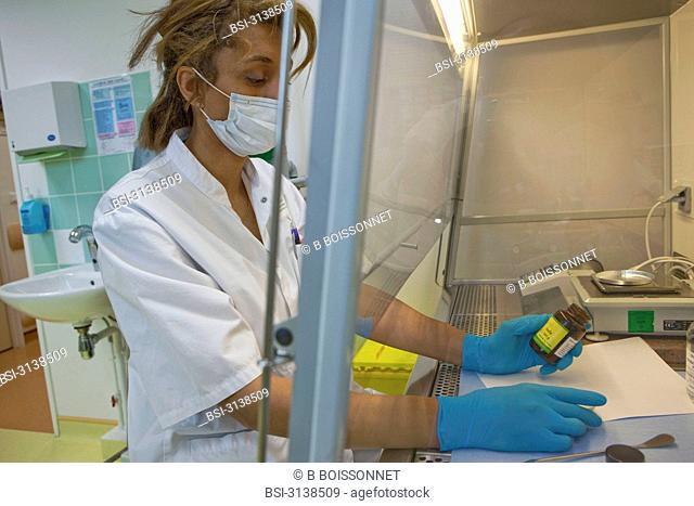 Photo essay at the hospital of Meaux 77, France. Hospital of Orgemont. Central pharmacy. Assistant in pharmacy under laminar flow hood. Iodine