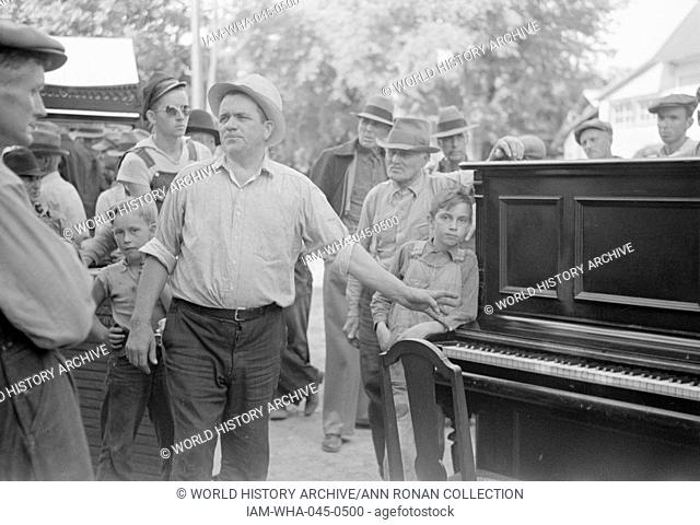 Photograph depicting auction sales in Greene County, which became frequent because as farm conditions became worse families move into smaller houses and sell...