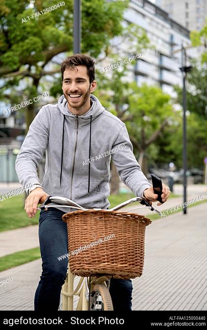 Young man riding bicycle in city