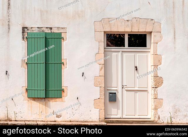 Door and window in traditional old house with white weathered facade in the Island of Re