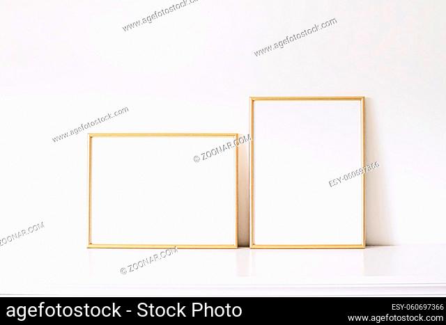 Two golden vertical and horizontal frames on white furniture, luxury home decor and design for mockup creations