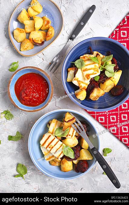 Spanish style dinner with baked potatoes, grilled halloumi, fried chorizo and ??tomato sauce