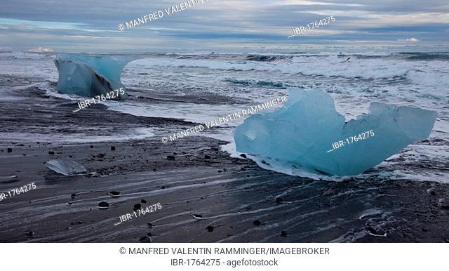 Icebergs on the beach hit by waves, Joekulsarlon glacier lagoon, Iceland, Europe