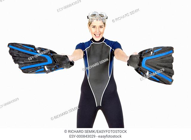 standing young woman wearing neoprene with flippers and diving goggles