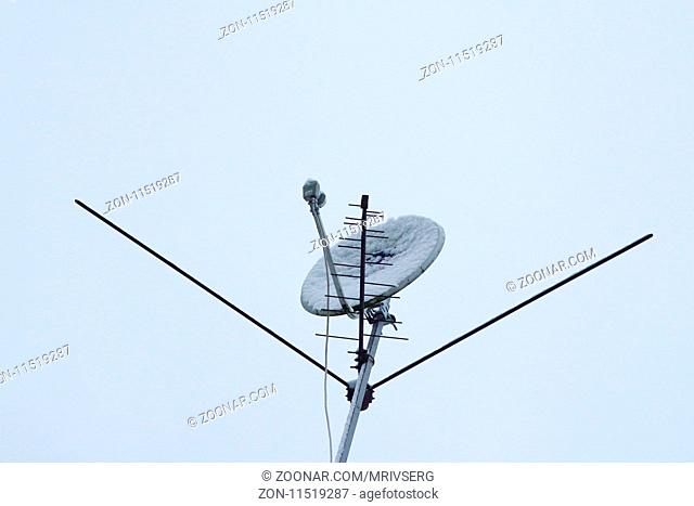 telecommunication space, television all-wave antenna and satellite dish under the snow