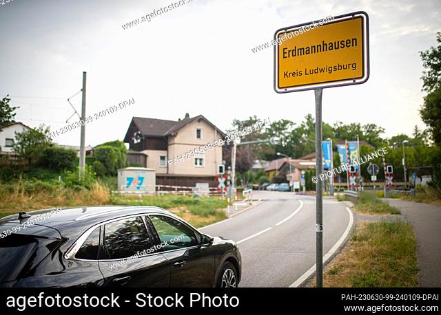 29 June 2023, Baden-Württemberg, Erdmannhausen: A car drives past the entrance sign to Erdmannhausen. Among other things