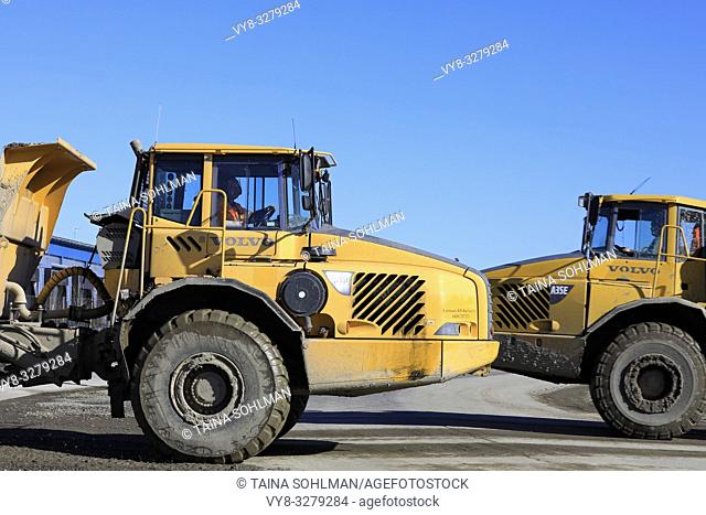 Lieto, Finland - March 22, 2019: Two Volvo articulated haulers, A35D and A35E, pass at speed by a construction site, side view