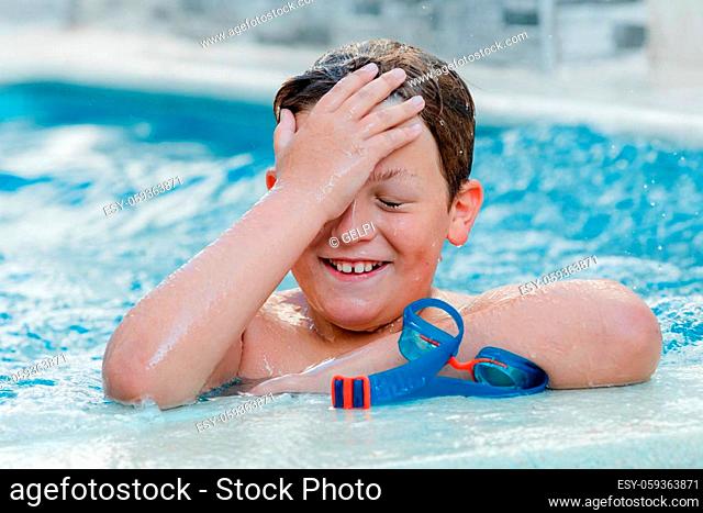 Beautiful blond child in the swimming pool on the summer