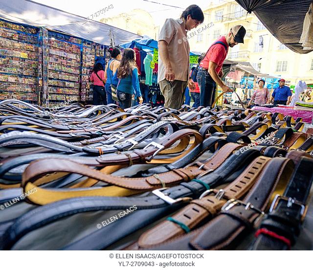 Men shopping for leather belts at the Zocalo market in Oaxaca Mexico