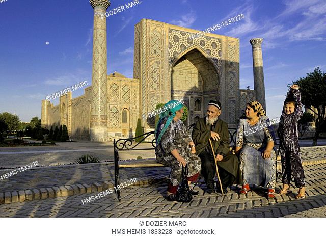 Uzbekistan, Silk Road, Samarkand, listed as World Heritage by UNESCO, Registan Square, Ferghana valley pilgrims in front of the Ulugh Beg Madrasah