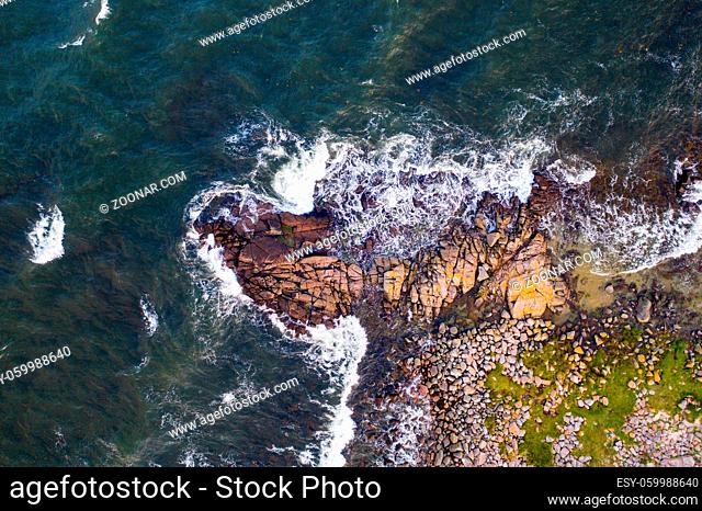 Bornholm, Denmark - August 10, 2020: Top down drone view of the rocky cliff coastline close Hammerknuden