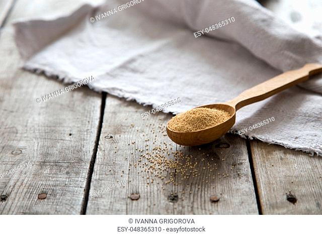 Amaranth seeds in a wooden spoon on table, selective focus. Raw Organic Amaranth Grain