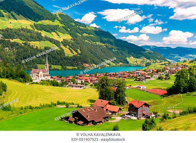 Swiss village Lungern with its traditional houses and Neo-Gothic church along the lake Lungerersee, canton of Obwalden, Switzerland