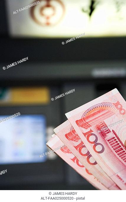 100 Yuan banknotes, AMT in background
