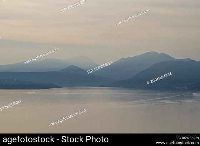 Gegenlichtaufnahme des südlichen Gardasees mit den umgebenden Hügeln der Gardaseeberge