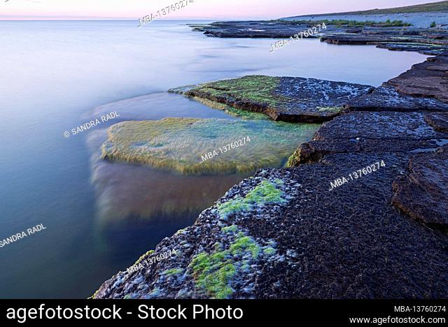 Evening mood on the coast at Byxelkrok, water laps the stone slabs in the sea, Sweden, Öland island