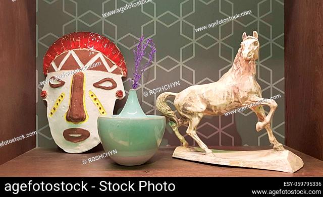 Ukraine, Kiev - June 10, 2020. Ceramic figurines and figures decoration or symbol in the home interior. Mask, a small vase
