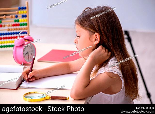 Little girl preparing for exams at home
