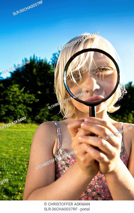 Girl playing with magnifying glass