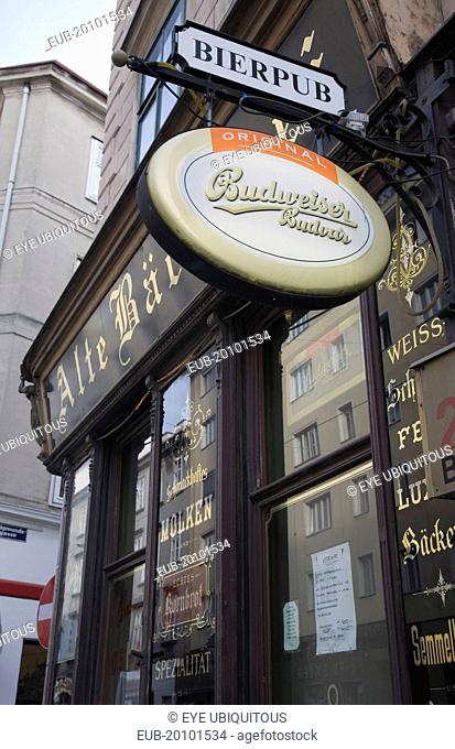 Angled view of pub facade with hanging beer signs