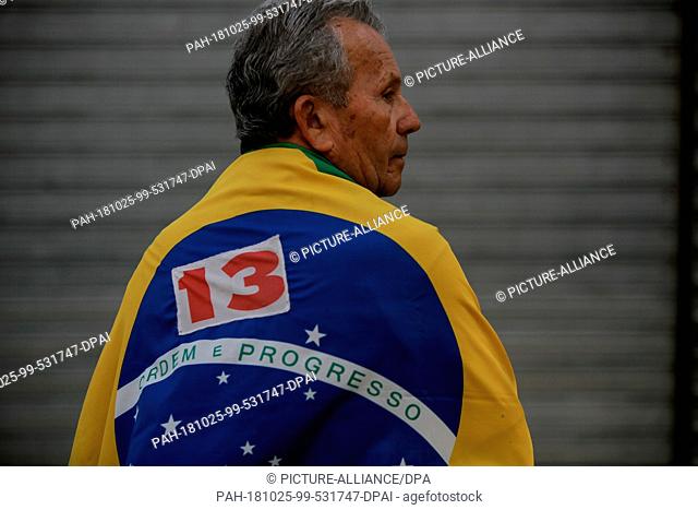25 October 2018, Brazil, Recife: A supporter of Haddad, presidential candidate of the Workers' Party in Brazil, is wearing a Brazilian flag at the last campaign...