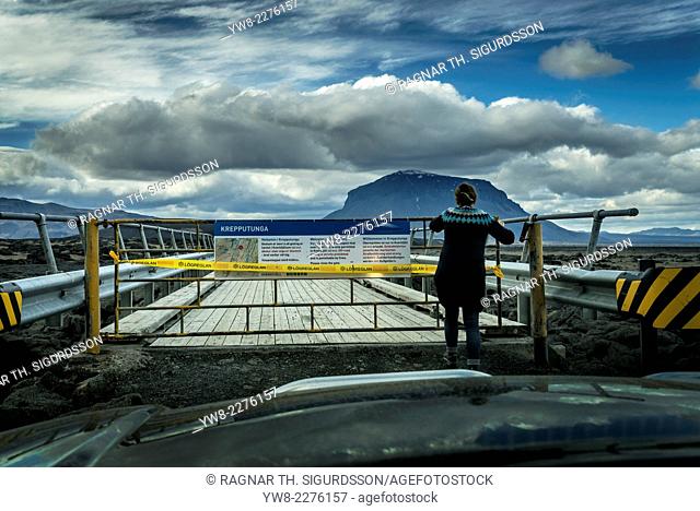 Woman standing by a closed bridge-Krepputunga area, by the Holuhraun Fissure Eruption, near the Bardarbunga Volcano, Iceland