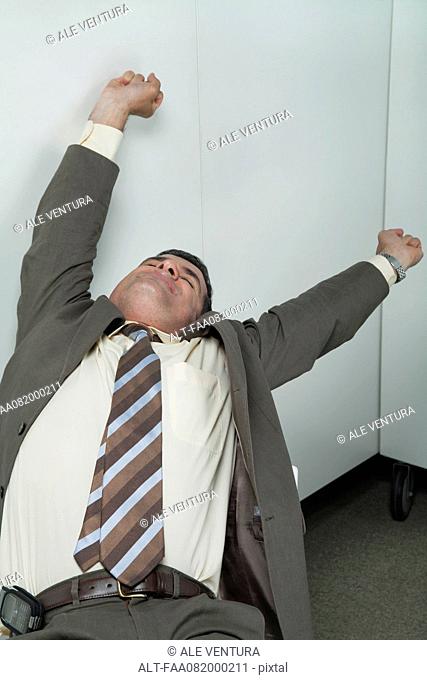 Businessman stretching in office