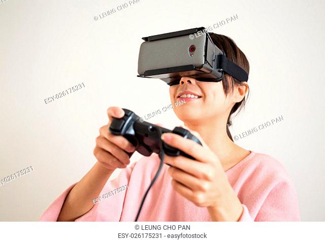 Thrilled woman play with joystick and vr device