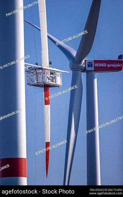27 May 2020, Mecklenburg-Western Pomerania, Dummerstorf: Specialists maintain a rotor blade from a nacelle at a wind turbine of the operator Wind-Projekt