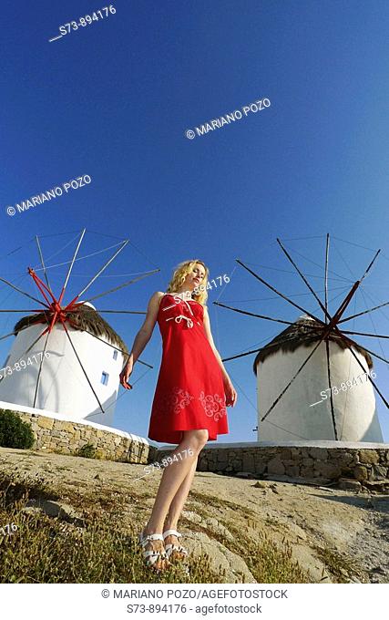 30 year old woman in front of windmill, Mykonos, Cyclades islands, Greece