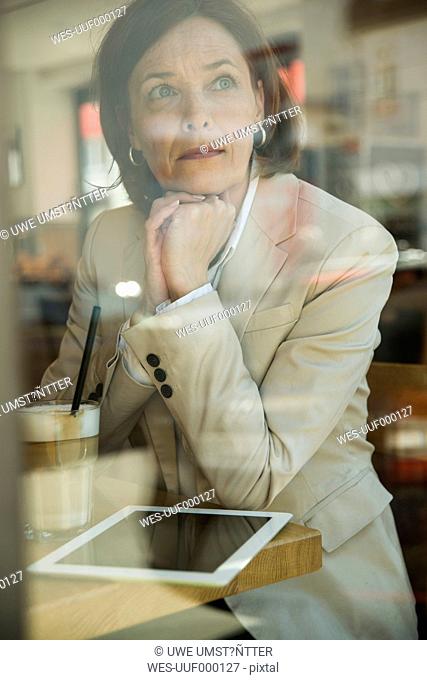 Portrait of business woman with tablet computer having a coffee break