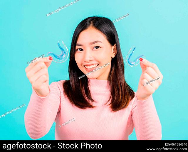 Portrait Asian beautiful young woman smiling hold silicone orthodontic retainers for teeth, Teeth retaining tools after removable braces