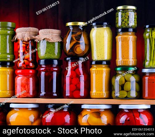 Jars with variety of pickled vegetables and fruits. Preserved food