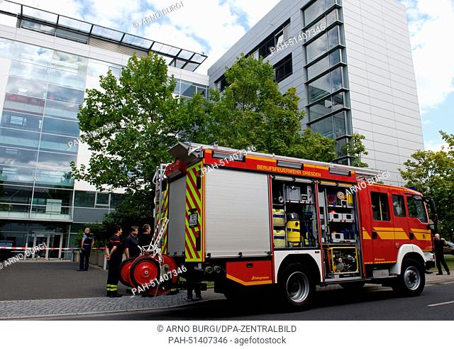 Fire fighters and police officers stand in front of an administration building of Siemens in Dresden, Germany, 25 August 2014