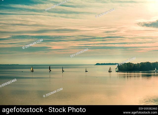 Sunrise over the river with yachts on a calm water surface in the summer time