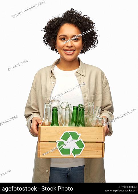 happy woman with bottles sorting glass waste