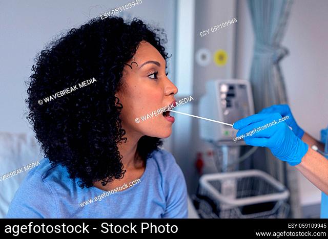 African american female patient with mouth open tested with swab test