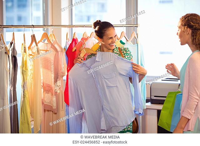 Woman showing shirt to her friend at shopping mall