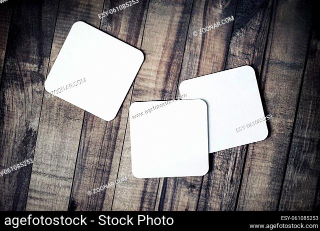 Photo of blank beer coasters on wooden background. Template for placing your design. Flat lay